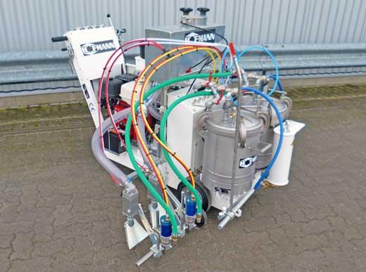 H9 Airspray avec deux réservoirs chacun pour une volume de 48 l, pour matériau blanc et jaune ainsi que avec deux pistolets de peinture et billes de verre