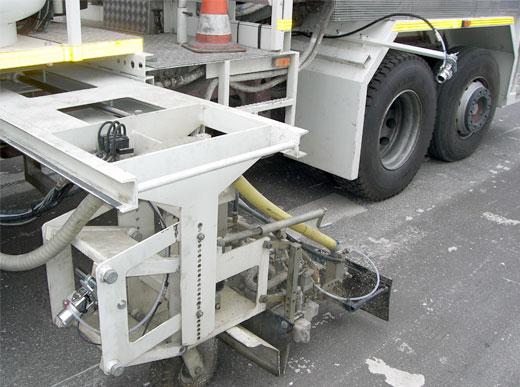 Système de caméra des deux côtés avec soufflante contre condensation et encrassement de la lentille, à l'exemple d'un camion de marquage pour enduits à chaud pulvérisés pour surveillance de la qualité du trait